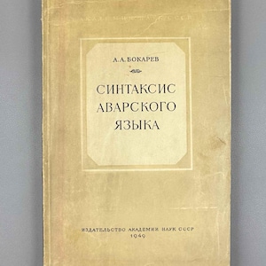 Puede incluir: Un libro de tapa blanda vintage con una cubierta de color tostado y desgastada. El título dice A.A. BOKAREV SINTAKSIS AVARSKOGO YAZYKA en cirílico, con la editorial y el año 1949 impresos en la parte inferior. La cubierta tiene un borde central.