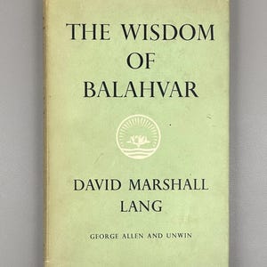 Puede incluir: Un libro antiguo titulado "The Wisdom of Balahvar" de David Marshall Lang. La portada del libro es de color verde claro con texto negro y un emblema circular. El nombre del editor, George Allen and Unwin, está en la parte inferior.