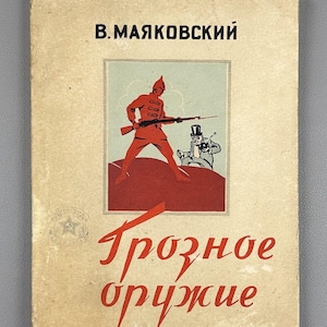 Może przedstawiać: Vintage okładka książki z tytułem "Tрожное оружие" w czerwonym skrypcie. Okładka przedstawia ilustrację żołnierza w kolorze czerwonym trzymającego karabin, z postacią z kreskówki w cylindrze. Nazwisko autora, B. Mayakovsky, znajduje się na górze.