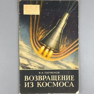 Può includere: Copertina di libro vintage a tema spaziale. Raffigura un'astronave con fiamme contro un cielo stellato e striature arancioni. Il titolo è in russo, con il nome dell'autore.