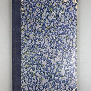 May include: A vintage book with a blue spine and cover. The cover features a light blue background with a repeating pattern of blue and green organic shapes. The book shows signs of wear.