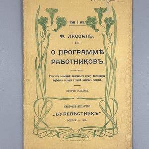 May include: Vintage book cover in Russian with green floral and scroll artwork on a tan backdrop. The title reads "O Programmě Rabotnikovъ" by F. Lassalle, published in 1905 by Burevěstnikъ in Odessa.