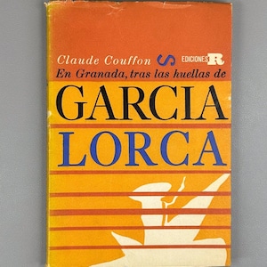 May include: A vintage book cover with an orange and yellow background. The title "GARCIA LORCA" is in large black and blue letters. The author's name, Claude Couffon, is at the top. The book is titled "En Granada, tras las huellas de".