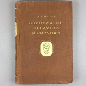 May include: A vintage brown book with gold lettering and a gold emblem featuring a bust. The title, in Russian, reads "Perception of Objects and Drawings." The book has a worn appearance, suggesting age and use.