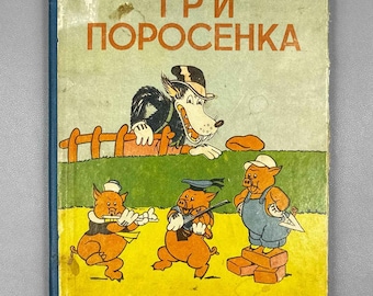May include: A vintage 1937 children's book titled "ТРИ ПОРОСЕНКА" featuring a color illustration of a wolf in a hat behind a fence and three pigs playing instruments and building with bricks on a yellow and green background.