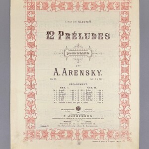 Op de afbeelding: Oude bladmuziekcover voor "12 Préludes Pour Piano" van A. Arensky. De cover heeft een decoratieve rode rand met bloemmotieven en zwarte tekst. De titel en de naam van de componist zijn prominent aanwezig.