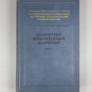 May include: A vintage blue book with Russian text. The title on the cover is "Dosimetry of Ionizing Radiation." The book shows signs of wear and age. Additional text in Russian is visible on the cover, indicating its historical context.