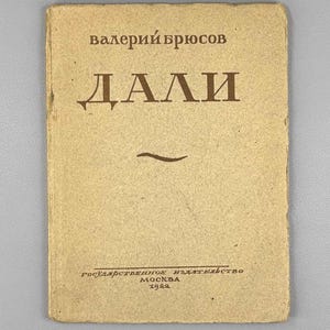 May include: A vintage book with a tan cover. The title "ДАЛИ" is in brown lettering, with the author's name "валерiй брюсов" above. The bottom of the cover has text in Russian and the year 1922.