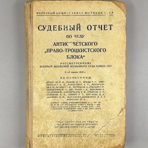 May include: A white ceramic mug with a black handle and the text "But First, Coffee" in a handwritten style. The mug is on a white surface. The mug is approximately 4 inches tall.