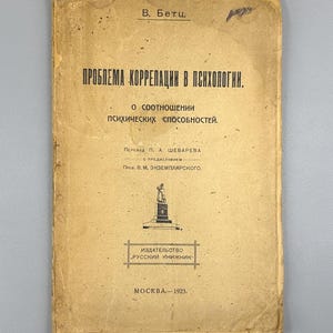 May include: A vintage book cover with text in Russian. The cover is a faded tan color with black text. The title reads "ПРОБЛЕМА КОРРЕЛАЦИИ В ПСИХОЛОГИИ" and the publication date is 1923. The book is from the publisher "РУССКИЙ КНИЖНИК".