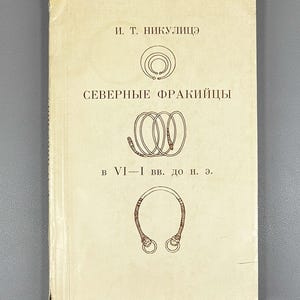 May include: A vintage book with a cream-colored cover featuring Cyrillic text and illustrations of ancient jewelry. The title reads "Northern Thracians" with additional text below. The book's design suggests a historical or archaeological theme.