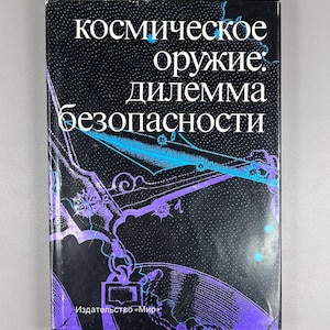 以下が含まれることがあります： 黒い表紙に白と青のロシア語のテキストが書かれたハードカバーの本。タイトルは「космическое оружие: дилемма безопасности」で、宇宙をテーマにしたデザインのイラストが描かれています。出版社の名前もロシア語です。