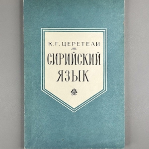 May include: A vintage book with a teal cover. The title, in Russian, is displayed in a white framed design. The text reads "K.G. Tsereteli" and "Syriac Language". A small floral design is at the bottom of the text.