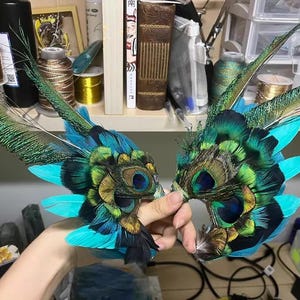 Puede incluir: Un par de m&aacute;scaras para los ojos hechas con plumas de pavo real. Las m&aacute;scaras presentan plumas de color turquesa, verde y negro, con detalles intrincados alrededor de las cuencas de los ojos. Dise&ntilde;adas para disfraces o decoraci&oacute;n.
