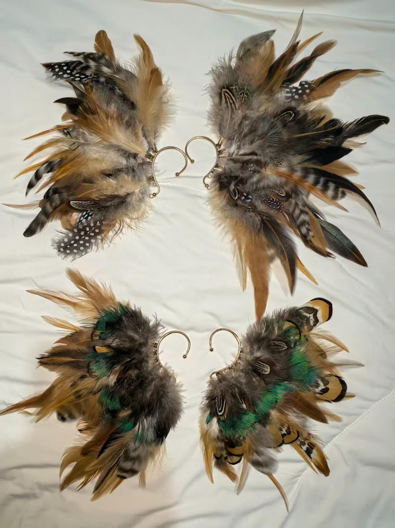 May include: Four pairs of feather ear cuffs. Each cuff features a cluster of brown, tan, black, and green feathers attached to a gold-colored ear wire. The feathers vary in size and texture, creating a layered effect.