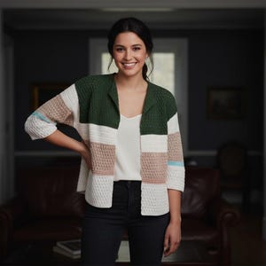 May include: A woman wearing a color-blocked cardigan. The cardigan features panels of green, white, tan, and light blue. The sleeves are three-quarter length. The woman is wearing a white top and black pants.