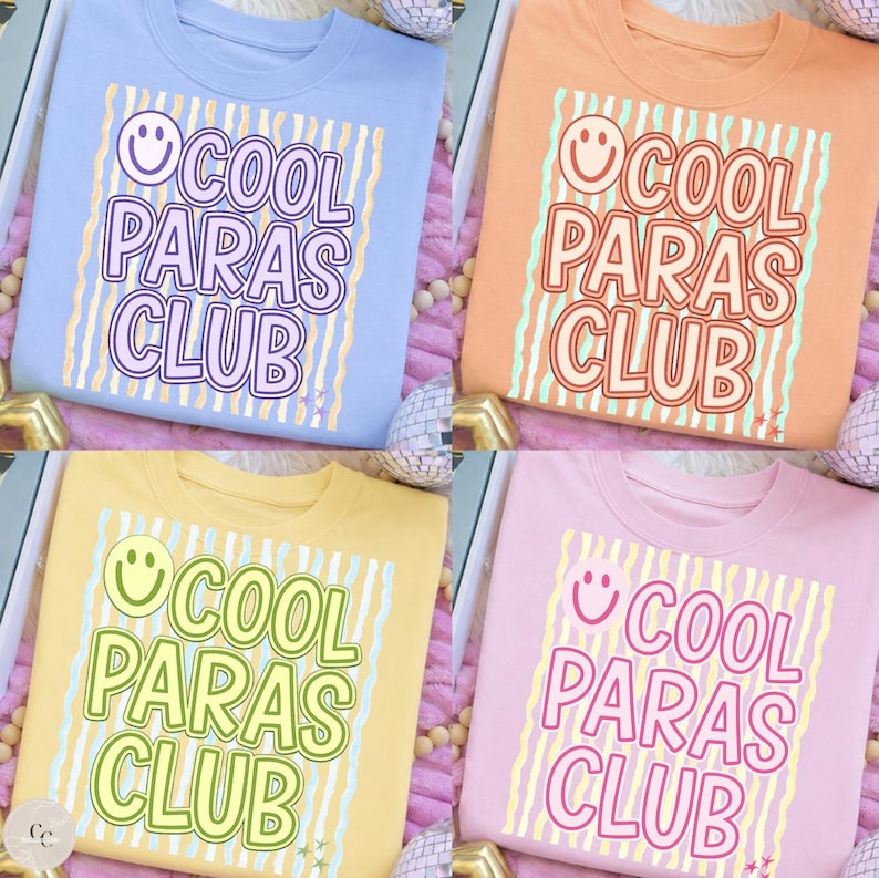 May include: Four crew neck sweatshirts in pastel colors: light blue, peach, yellow, and pink. Each shirt features the text "COOL PARAS CLUB" in a bold, playful font with a smiling face graphic. Vertical striped background.
