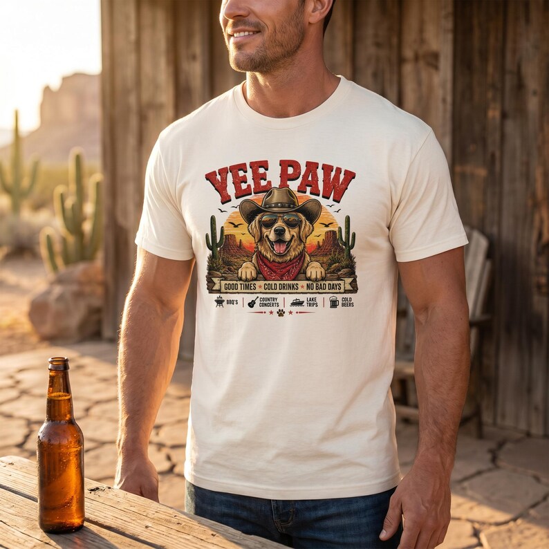 K&ouml;nnte beinhalten: Cremefarbenes T-Shirt mit einem Aufdruck eines Hundes mit Cowboyhut und Halstuch, mit dem Text "Yee Paw". Das Design beinhaltet Kakteen und den Satz "Good Times, Cold Drinks, No Bad Days."