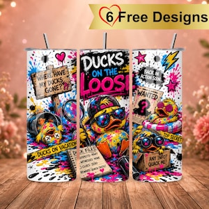 Könnte beinhalten: Drei zylindrische Becher mit Strohhalmen und einem bunten Graffiti-Design mit gelben Enten. Der Text umfasst "Where have my ducks gone?", "Ducks on the loose", "Wanted", "Back in action soon", "Top secret" und "Any info? Quack me!".