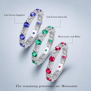 Peut inclure: Trois bagues éternité avec des pierres rondes. Une bague contient du saphir de culture, une de l'émeraude de culture, et une de la moissanite et du rubis. Les autres pierres sont en moissanite. Chaque bague est sur un anneau en métal argenté.