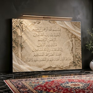 May include: A rectangular wall art piece featuring the Arabic text of Surah Al-Fatiha in gold calligraphy on a textured beige stone-like background. The design includes cream-coloured fabric drapes and intricate architectural arch motifs.