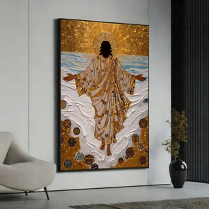 May include: A rectangular wall art piece featuring a central figure with arms outstretched, wearing a white robe with gold accents. The background displays a textured gold sunburst, blue waves, and scattered circular motifs in gold and brown tones.