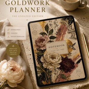 Op de afbeelding: Een digitale tablet met een Goldwork Planner-omslag met bloemillustraties, gouden accenten en een kolibrie. Het scherm toont de tekst Notebook, Thoughts, Ideas, Dreams en Paeonia officinalis. De tablet ligt op een gestructureerd oppervlak.