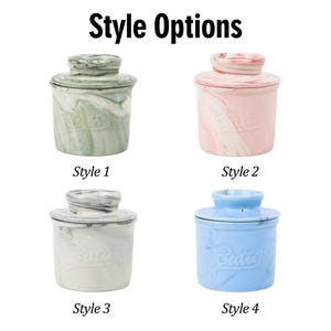 Puede incluir: Cuatro mantequilleras de cer&aacute;mica en diferentes colores: verde, rosa, gris y azul. Cada plato tiene una tapa y est&aacute; etiquetado con "Style" y un n&uacute;mero. El texto "Style Options" est&aacute; en la parte superior.