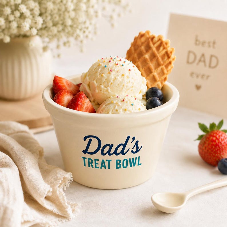 Pu&ograve; includere: Una ciotola in ceramica color crema con la scritta blu scuro Dad's TREAT BOWL stampata sul davanti. La ciotola &egrave; riempita con due palline di gelato alla vaniglia guarnite con zuccherini colorati, un biscotto a cialda, fragole e mirtilli.