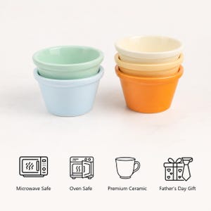 Pu&ograve; includere: Due pile di pirottini in ceramica in colori pastello e vivaci. La pila a sinistra presenta una ciotola verde chiaro sopra una azzurra. La pila a destra include una ciotola color crema, una gialla e una arancione. Le icone indicano la sicurezza nel microonde.