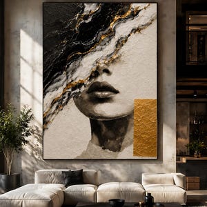 May include: A large rectangular wall art piece featuring an abstract portrait of a face partially obscured by black, white, and gold textured paint strokes. A solid gold rectangular block is positioned on the lower right side of the canvas.