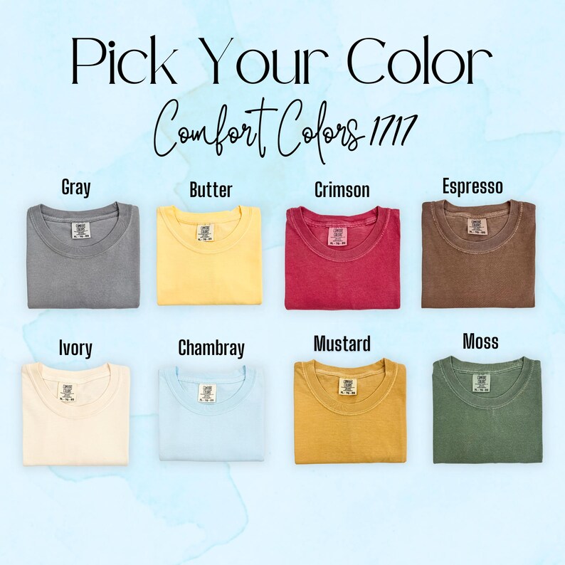 May include: A color chart displaying eight folded t-shirts labeled Pick Your Color Comfort Colors 1717. The shirts are in gray, butter, crimson, espresso, ivory, chambray, mustard, and moss. Each shirt features a visible interior neck label.