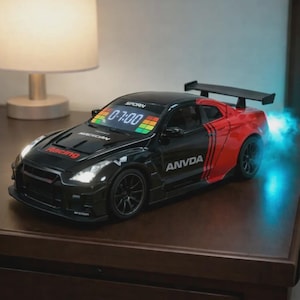 Könnte beinhalten: Eine schwarz-rote Digitaluhr in Form eines Sportwagens mit Heckspoiler. Die Windschutzscheibe zeigt die Uhrzeit 0:7:00 in weißen Ziffern mit bunten Grafikbalken. Das Wort Racing steht auf der Motorhaube und ANVDA an der Seite. Blaues Licht strahlt vom Heck aus.