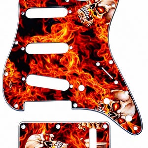May include: Guitar pickguard and control plate with a fiery skull design. The pickguard has three pickup cutouts and screw holes. The control plate has a single cutout. The design features flames in red, orange, and yellow, with skull imagery.