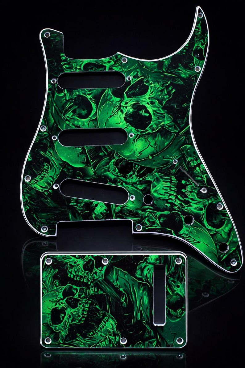 Puede incluir: Un juego de golpeador y placa de control para guitarra con un vibrante patr&oacute;n de calaveras verdes. El golpeador tiene tres recortes para pastillas y m&uacute;ltiples orificios para tornillos. La placa de control tiene un solo recorte.
