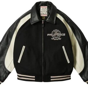 May include: Black and cream-colored varsity jacket with leather sleeves and collar. Features a "PALACE" emblem on the chest and striped cuffs. The jacket has a zipper closure and two front pockets with white trim.