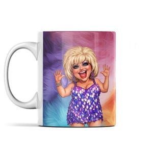 May include: White ceramic mug featuring a cartoon illustration of a smiling person with blonde hair, wearing a purple sequined dress. The background has a colorful, feathered design in shades of purple, blue, and orange.