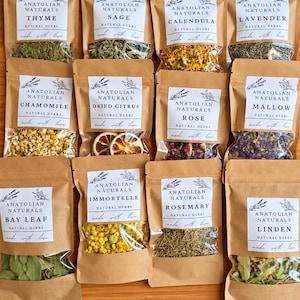 May include: Twelve brown paper pouches containing various dried herbs and flowers, each with a white label reading Anatolian Naturals. Varieties include thyme, sage, calendula, lavender, chamomile, dried citrus, rose, mallow, bay leaf, immortelle, rosemary, and linden.