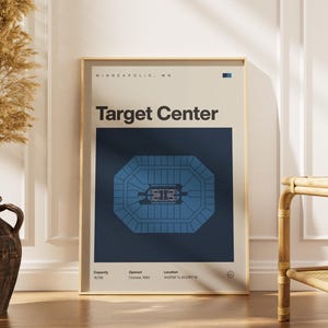 May include: A framed poster featuring the Target Center arena in Minneapolis, MN. The poster has a cream-colored background with the arena's layout in blue. Text includes "Target Center," capacity, opening date, and location coordinates.