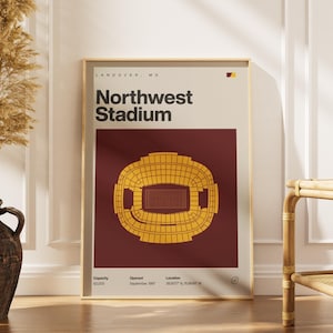 Pode incluir: Pôster emoldurado com uma moldura dourada, retratando o Northwest Stadium em Landover, MD. O design apresenta uma ilustração dourada do estádio em um fundo bordô, com parte superior e texto creme. Inclui capacidade, data de abertura e detalhes da localização.