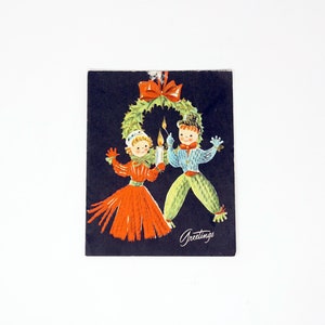 Vintage tarjeta de Navidad 50s ilustración navideña Carolers muñecas Yule vela verde corona roja cinta negro Kitsch medio siglo saludo de alegría