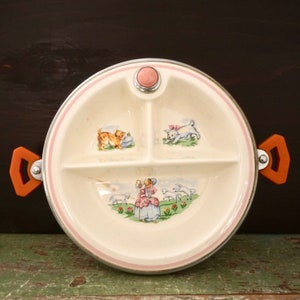 May include: A vintage divided plate with a pink rim and orange handles. The plate features three compartments with illustrations of a cat, a lamb, and a girl with sheep.