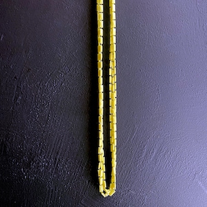 May include: A yellow chain necklace made of small square links.