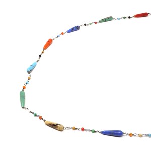 May include: A colorful necklace with a silver chain and various colored gemstone beads. The beads are shaped like long teardrops and are strung on a silver chain.