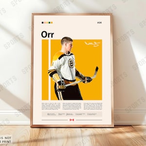 May include: A framed poster featuring a hockey player in a black, white, and yellow uniform. The poster has the name "Orr" in large letters, with the number "04" in the upper right corner. The poster is in a wooden frame.