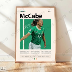 Könnte beinhalten: Ein gerahmtes Poster mit einer Fußballspielerin in einem grünen Trikot mit der Nummer 11. Das Poster enthält den Namen "McCabe", eine Unterschrift und Text über die Spielerin. Der Hintergrund ist hellbeige mit grünen und weißen Akzenten.