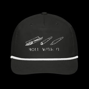 May include: Black baseball cap with a white rope detail and a curved brim. The cap features a white graphic of three rolled items and the text "ROLL WITH IT" in white.