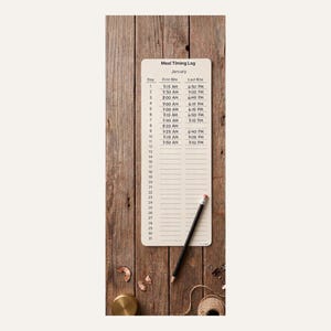 Puede incluir: Un registro de tiempo de comidas beige para enero, con un lápiz, sobre un fondo de madera. El registro tiene columnas para el día, el primer bocado y el último bocado. El lápiz es negro con una goma de borrar rosa.