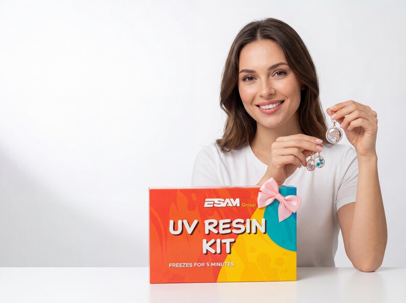 May include: A woman holds two resin pendants next to a box labeled "UV RESIN KIT". The box is red, orange, yellow, and teal, with a pink bow. The pendants are round, with floral and colorful inclusions.
