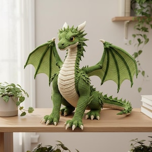 May include: A handcrafted green crochet dragon with detailed wings, horns, and a cream-colored belly. The dragon is posed on a wooden surface, showcasing its intricate design and texture. This fantasy-themed item is perfect for home decor or as a unique gift.
